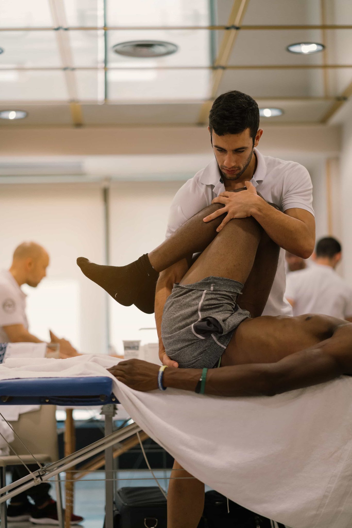 A practitioner guiding a guest's leg through a fascial movement session